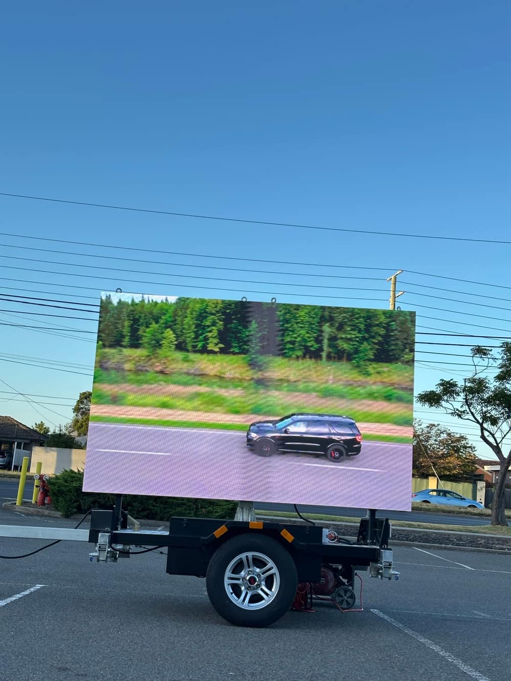 The trailer running as an LED screen, playing a short video of a car driving through open countryside