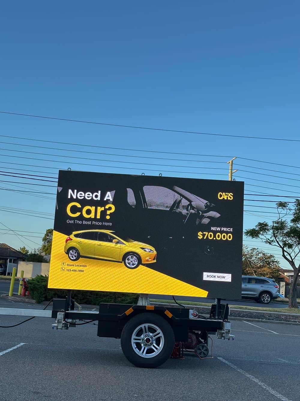 LED trailer sign showing a car-dealership advertisement with a vehicle image, price and a 'Book Now' call to action